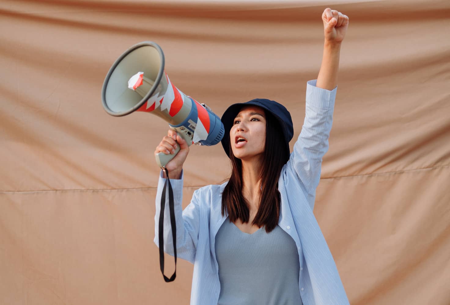 Una mujer protesta con un megáfono