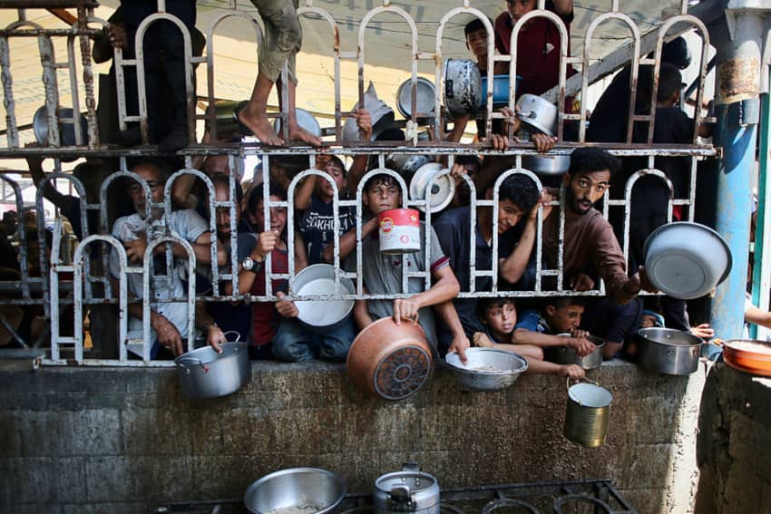 Personas palestinas esperando alimentos en Gaza, ejemplo de la crisis humanitaria y de la vulneración del derecho humano a una alimentación...