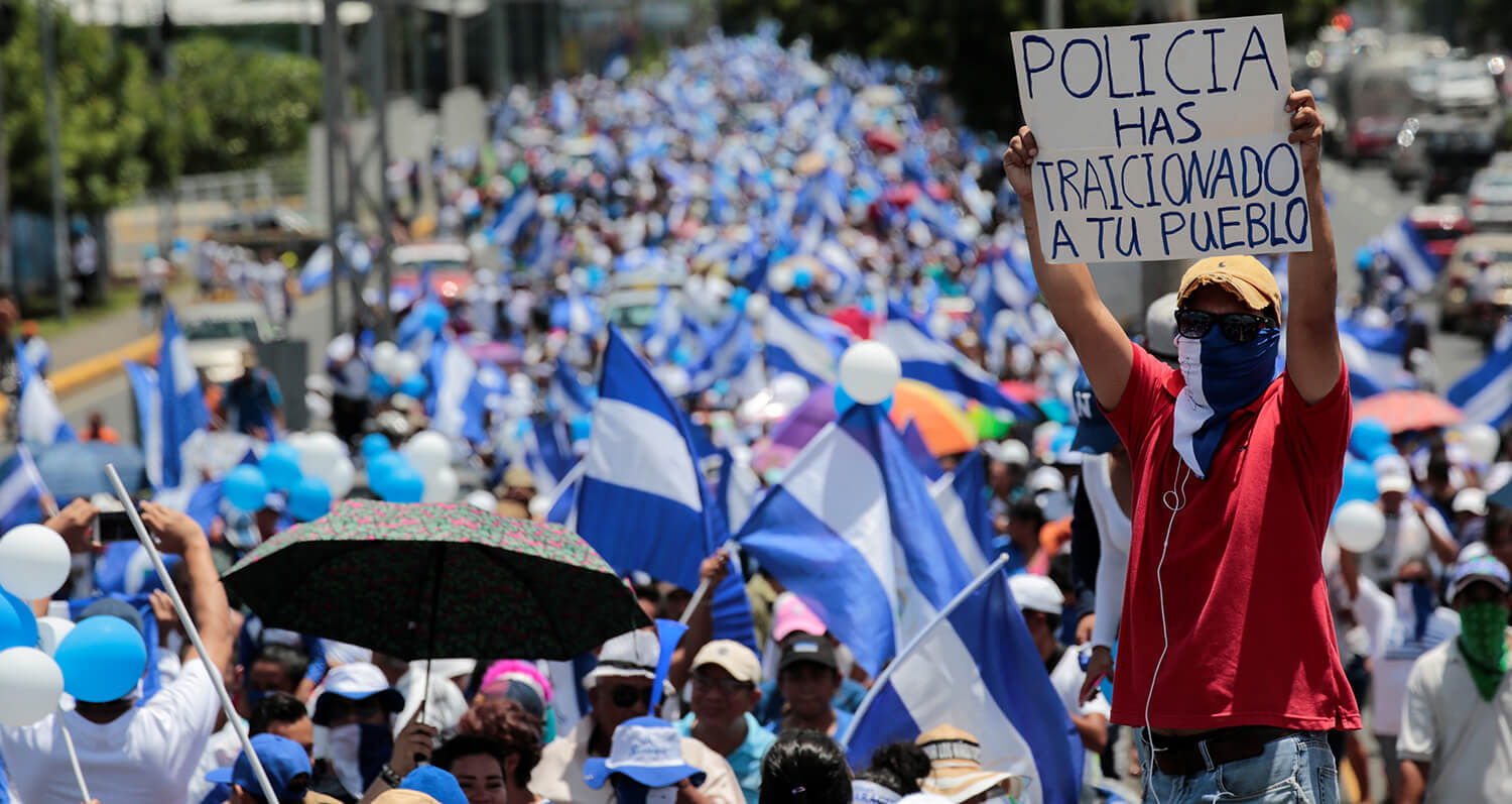 Un manifestante antigubernamental sostiene un letrero que dice "La policía ha traicionado a su pueblo" durante una protesta contra el gobierno del...