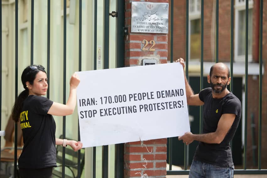Activistas de Amnistía Internacional protestan frente a la embajada de Irán en La Haya con un cartel que exige detener las ejecuciones de manifestantes.