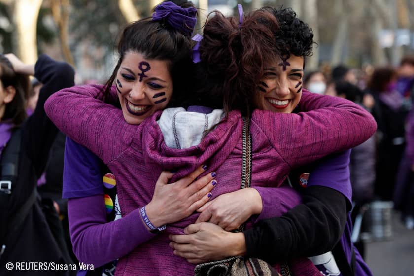 Tres mujeres abrazándose en una marcha del 8M