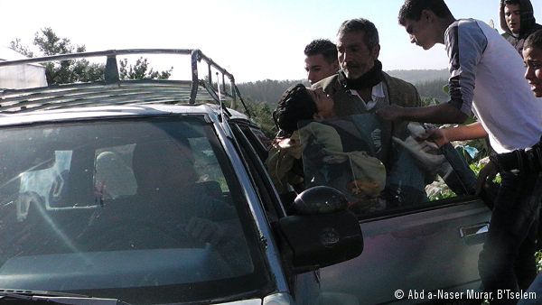 Samir Awad es subido a un coche para ser trasladado al hospital