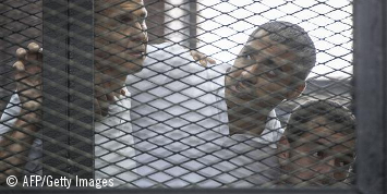 Peter Greste, Mohamed Fahmy y Baher Mohamed escuchando el veredicto en la jaula de los acusados
