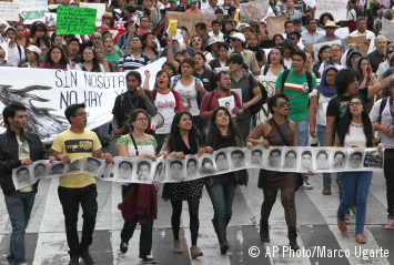 Varias personas portan imágenes de los estudiantes desaparecidos durante una manifestación