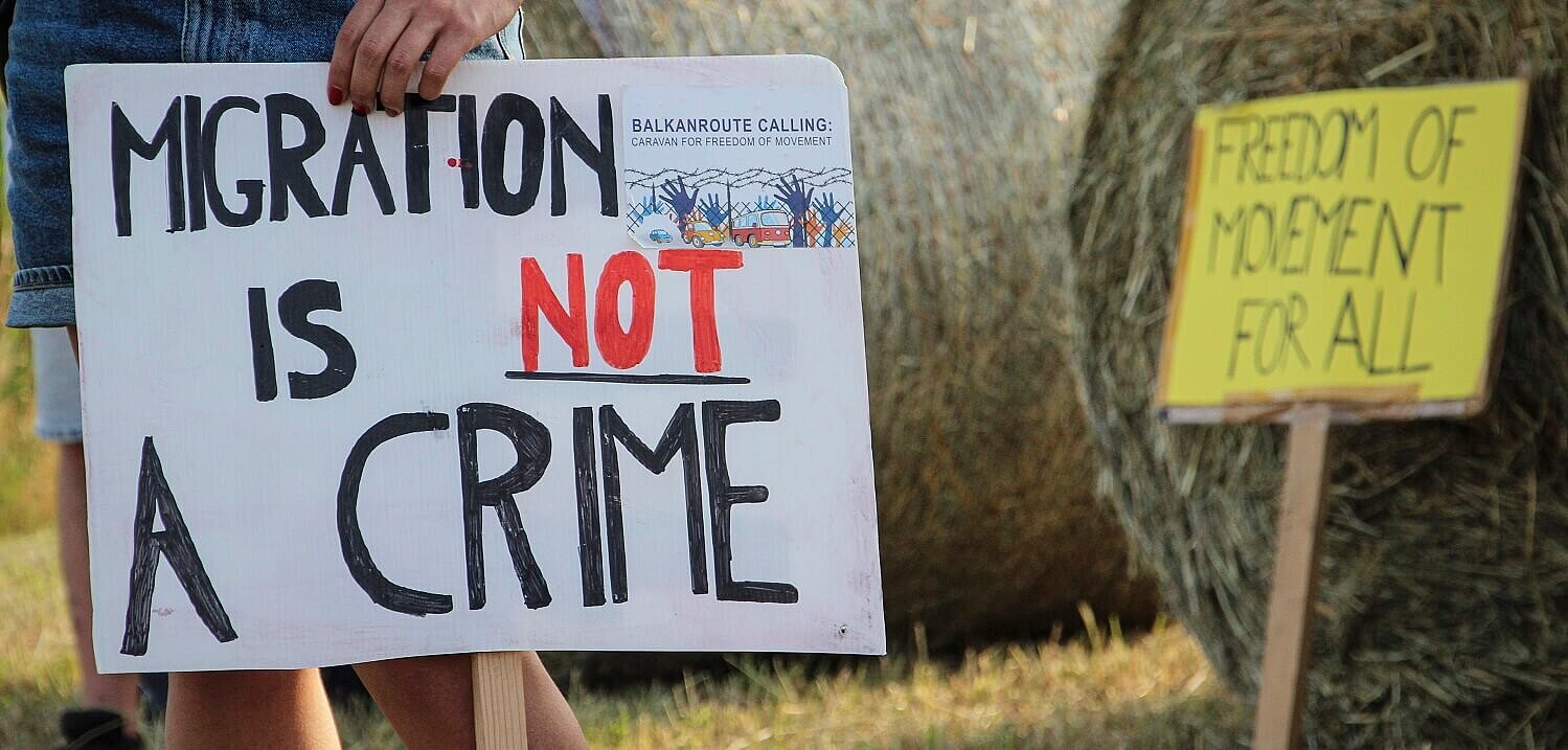 Una mujer sostiene una pancarta durante una protesta contra las violentas expulsiones de personas migrantes y refugiadas Una mujer sostiene una pancarta durante una protesta contra las violentas expulsiones de personas migrantes y refugiadas