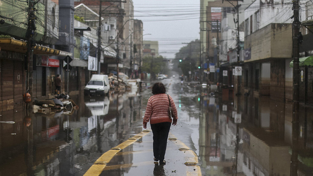 Mujer andando por una carretera inundada