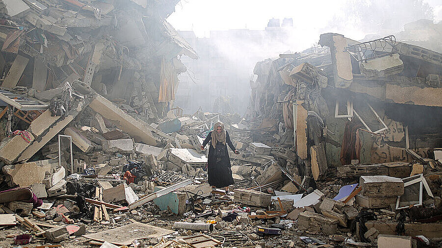 Una mujer anda por los escombros en el barrio de Zahra en la Franja de Gaza. 19 de octubre de 2023