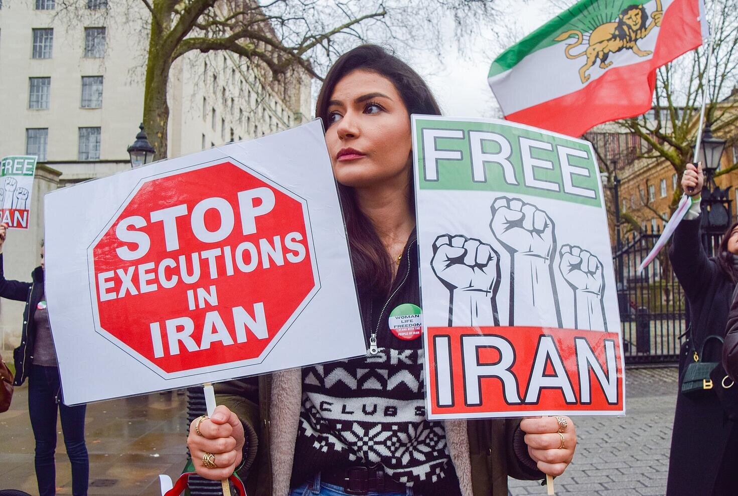 Manifestante con carteles contra la pena de muerte y por la libertad en Irán.