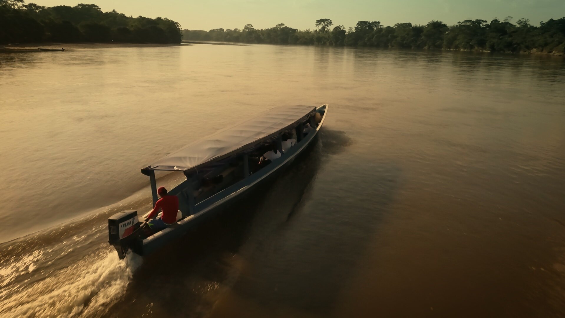 Río transitado por un bote en la reserva campesina de la Perla Amazónica