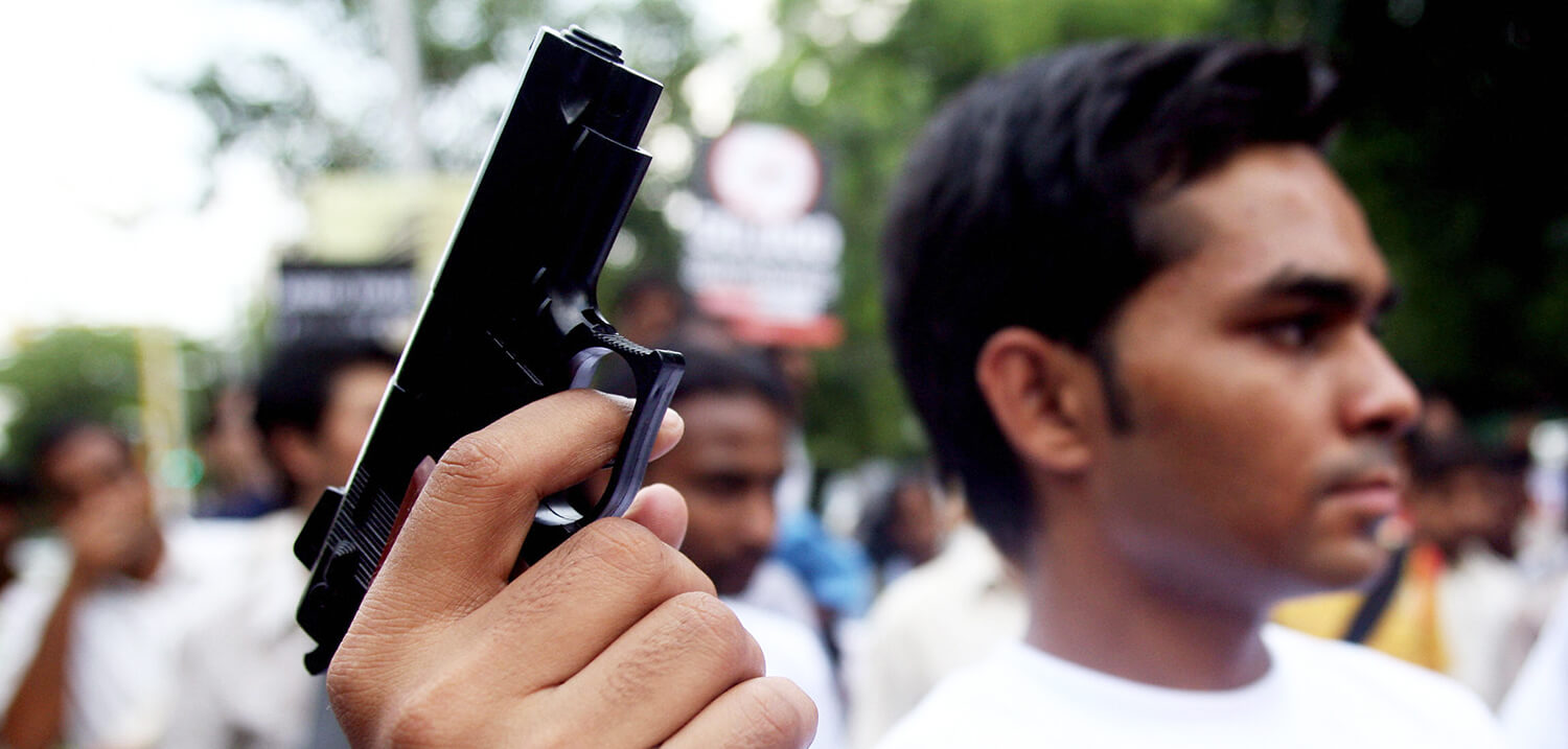 Un activista de la campaña Armas Bajo Control sostiene una pistola de juguete durante una protesta contra las armas en Nueva Delhi, el 13 de...