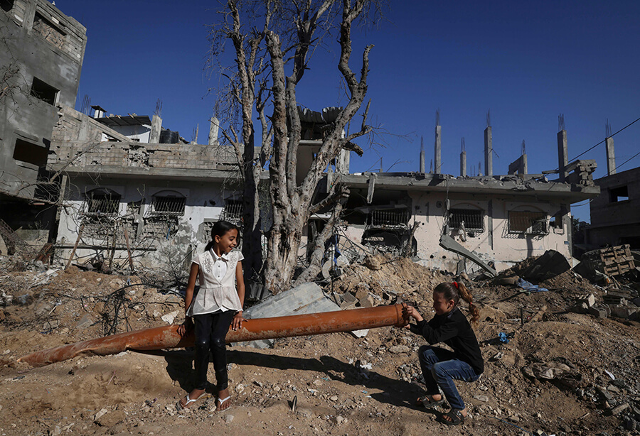 Unas niñas palestinas juegan entre los escombros