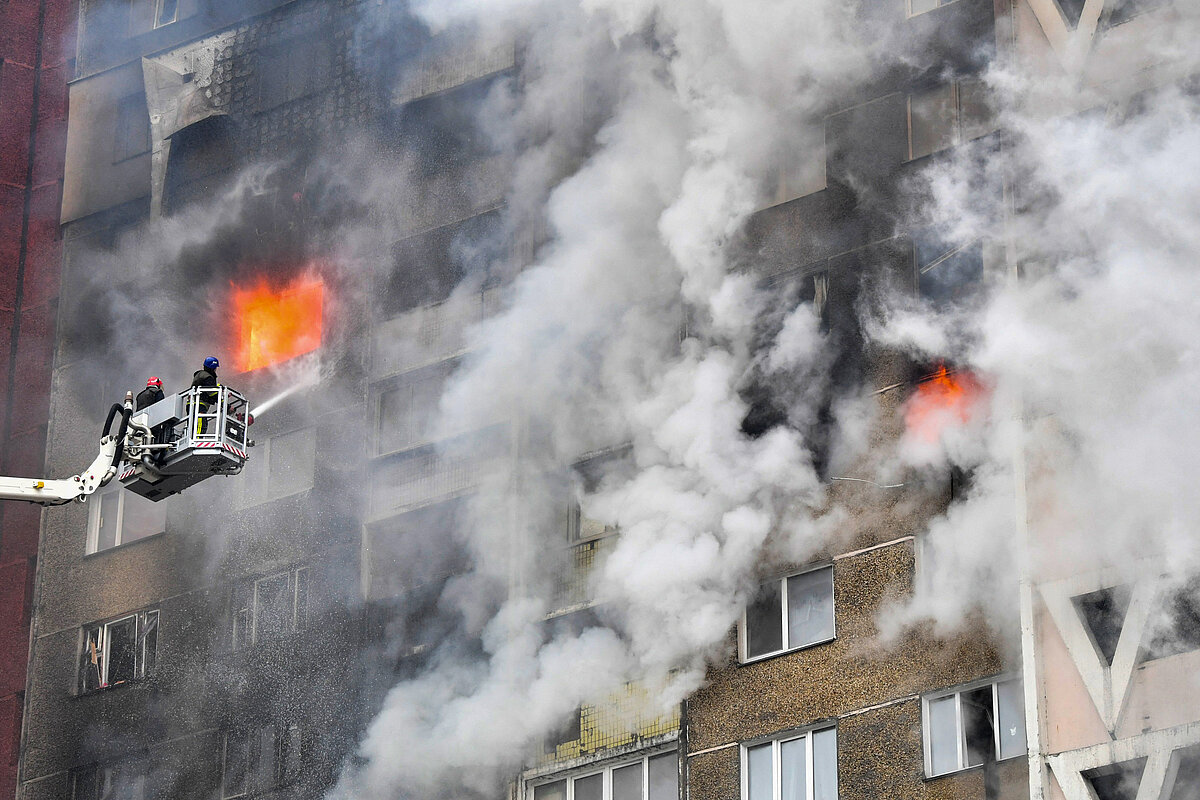 Un equipo de rescate ucraniano extingue un incendio en un edificio residencial tras un ataque con misiles en Kiev el 7 de febrero de 2024, en medio...