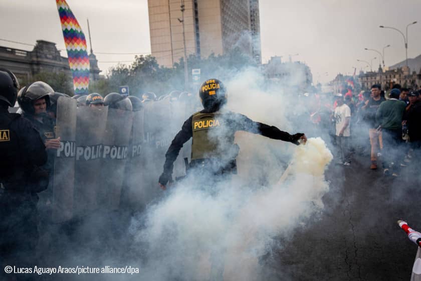 Un policía usa gases lacrimógenos contra manifestantes