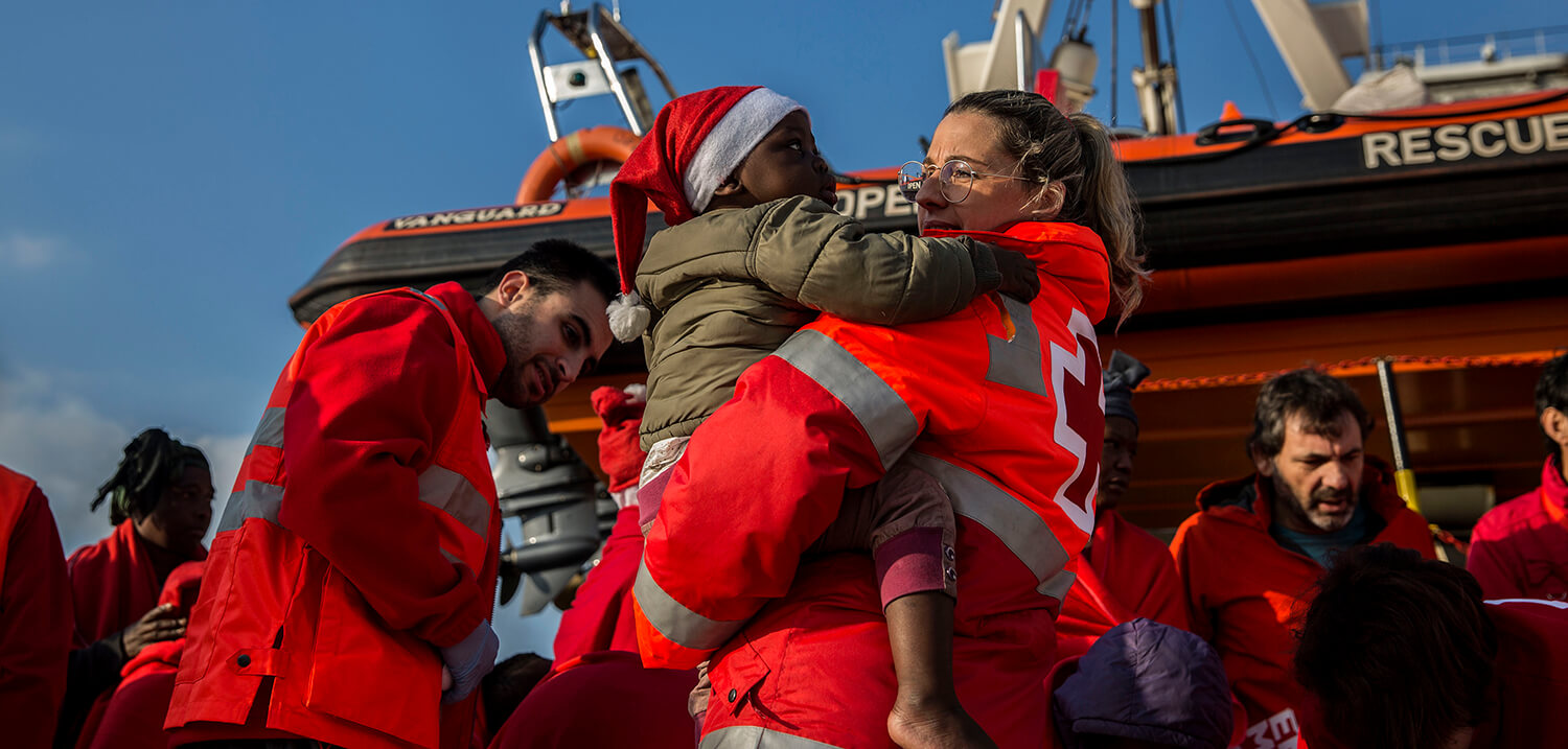 Un niño migrante es desembarcado del barco de rescate de la ONG española Proactiva Open Arms en el puerto de Crinavis en Algeciras.