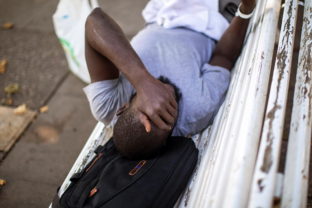 Abu Salem, de 30 años, de Senegal, descansa en un banco del parque en Fraga, Huesca, España, el jueves 2 de julio de 2020. Las autoridades del...