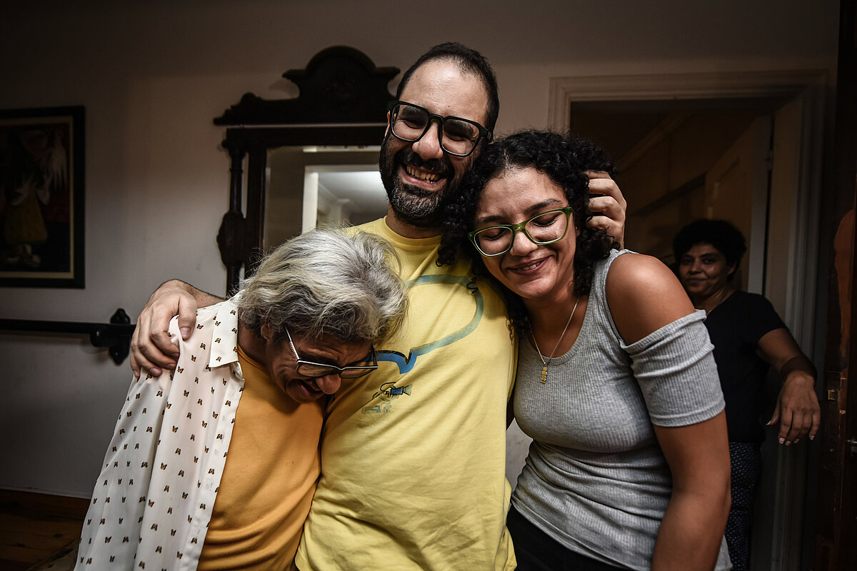 El activista egipcio-británico Alaa Abd El-Fattah (C) abraza a su madre, Laila Soueif, y a su hermana Sanaa, al llegar a su casa en El Cairo tras...
