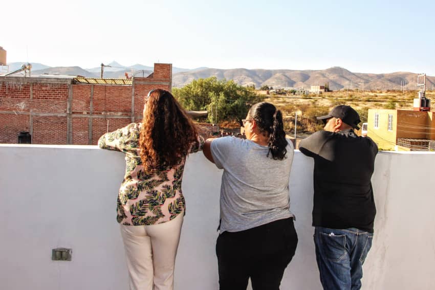 Tres integrantes del colectivo de familias buscadoras “Hasta Encontrarte” observan el horizonte desde una azotea en Guanajuato, México, símbolo de...