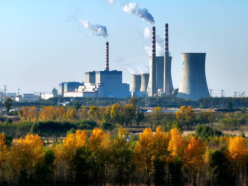 Instalaciones industriales con humo saliendo de las chimeneas, reflejando la contaminación del aire y su impacto climático.