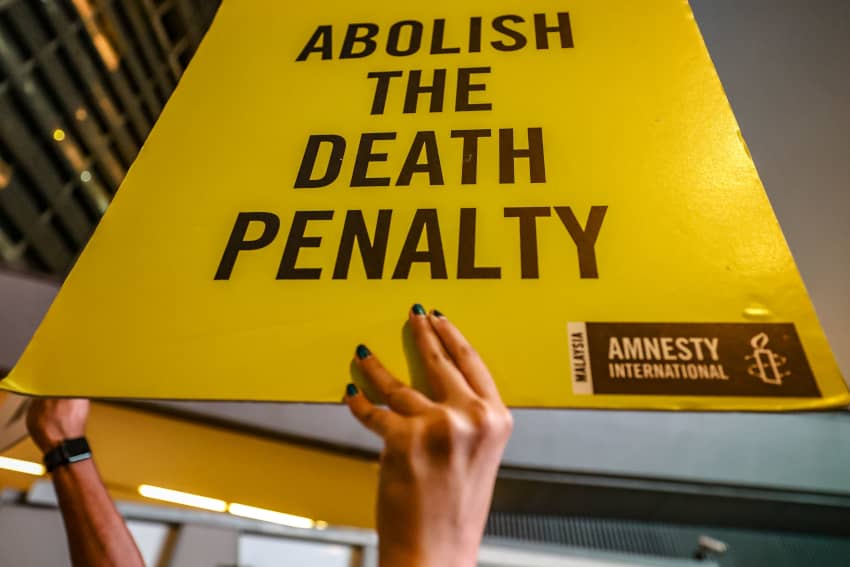 Cartel amarillo de Amnistía Internacional con el mensaje “Abolish the death penalty”, símbolo de la campaña global por la abolición de la pena de...