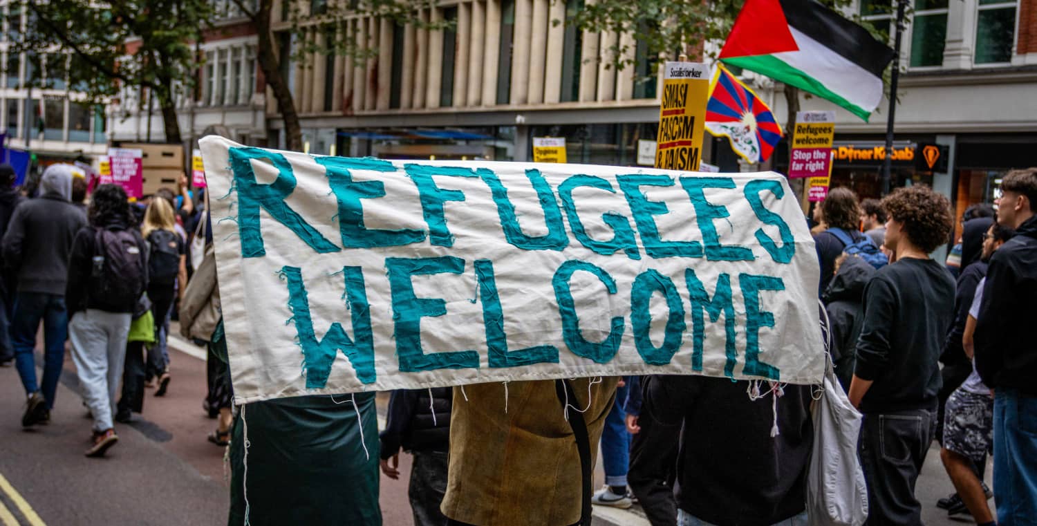 Pancarta “Refugees Welcome” en protesta en defensa de las personas solicitantes de asilo y contra políticas migratorias restrictivas.