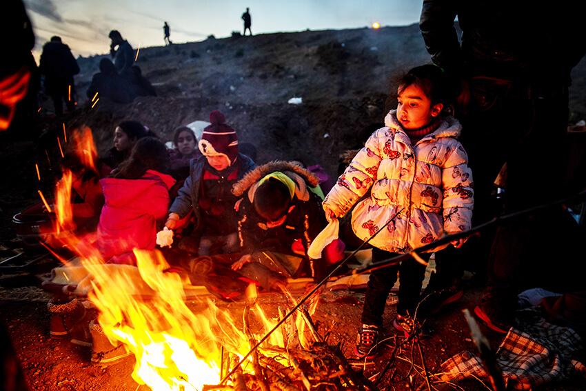 Personas refugiadas y migrantes se calientan junto al fuego mientras intentan entrar en Grecia desde Turquía, 1 de marzo de 2020 en Edirne, Turquía
