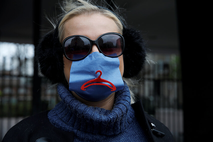 Una activista, con una mascarilla protectora en medio del brote del coronavirus, protesta contra una iniciativa para endurecer el acceso al aborto frente al Parlamento en Varsovia, Polonia, 15 de abril de 2020. 