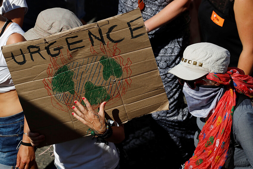 Un manifestante sostiene un cartel con la palabra "Emergencia" para instar a los líderes mundiales a actuar contra el cambio climático durante una marcha contra el G7 en Hendaya, durante la cumbre del G7 en Biarritz, Francia, 24 de agosto de 2019