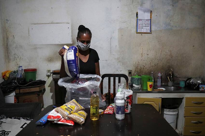 Miriam dos Anjos desempaqueta la ayuda alimentaria que recibió de Central Unica das Favelas (CUFA), una organización no gubernamental brasileña, en medio del brote de coronavirus (COVID-19) en el barrio marginal de Heliopolis en Sao Paulo, Brasil, 18 de junio de 2020