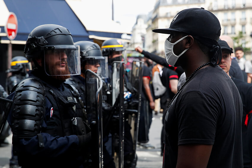 Un manifestante se enfrenta a un miembro de la policía antidisturbios francesa durante una protesta contra la brutalidad policial, la desigualdad racial y la muerte en la custodia policial de George Floyd, 20 de junio de 2020. 
