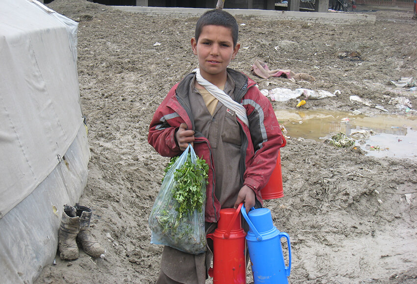 Un chico de 14 años, que vive en el asentamiento de desplazados internos de Chaman-e- Babrak, compra verduras en el mercado local, donde vende té para ganarse la vida. 