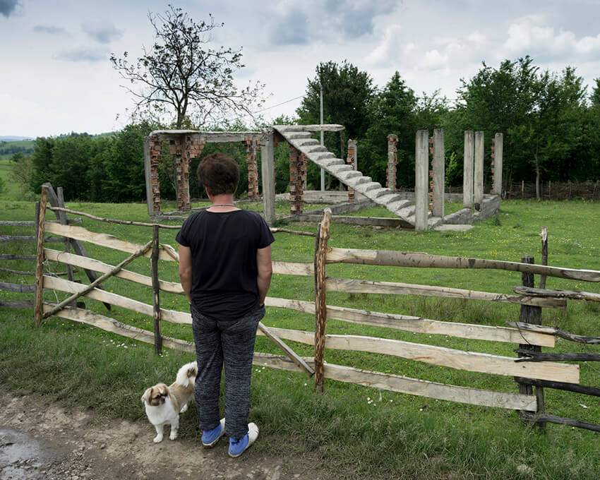 Una sobreviviente de violencia sexual mira una casa familiar destruida en el este de Bosnia