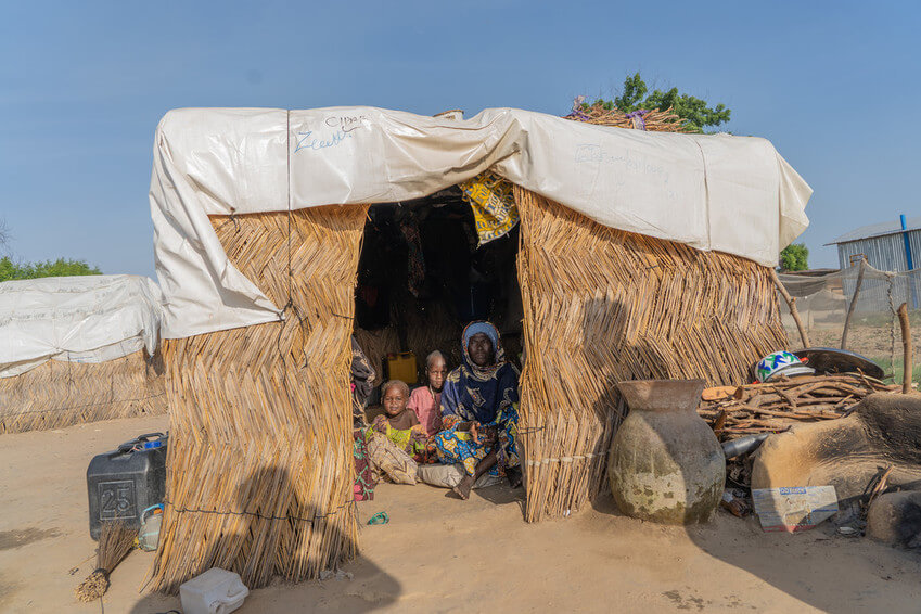 Falmata, de unos 60 años, sentada en su refugio con dos de sus nietos, en un campo de desplazados internos del estado de Borno, en el noreste de Nigeria, en octubre de 2020. Dice que el padre de los pequeños murió durante su detención.