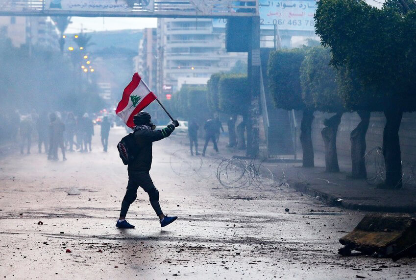 Un manifestante libanés antigubernamental ondea una bandera nacional durante los enfrentamientos con las fuerzas de seguridad