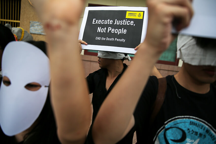 Manifestantes de Amnistía Internacional sostienen pancartas frente a la Prisión Central de Bang Kwang para protestar contra la pena de muerte en Bangkok, Tailandia
