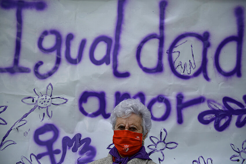 Una residente de la residencia de ancianos San Jerónimo posa frente a una pancarta que recoge la palabra "Igualdad".