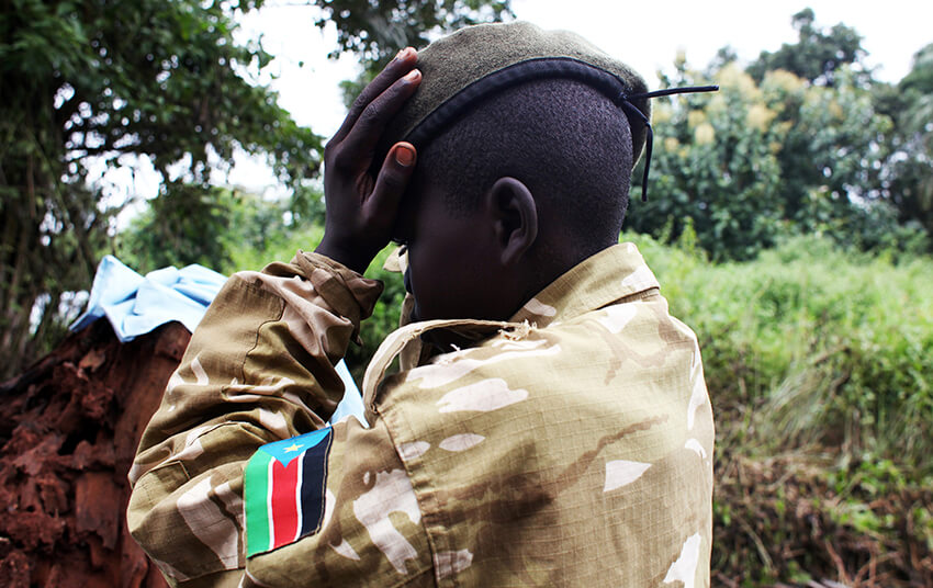 Un ex niño soldado arregla su boina mientras asiste a una ceremonia de liberación de niños y niñas soldados, en las afueras de Yambio, Sudán del Sur, el 7 de agosto de 2018. 
