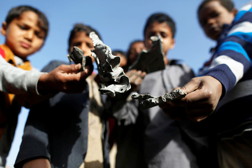 Unos niños sostienen la metralla de un misil que recogieron en el lugar de un ataque aéreo liderado por Arabia Saudí en Saná, Yemen