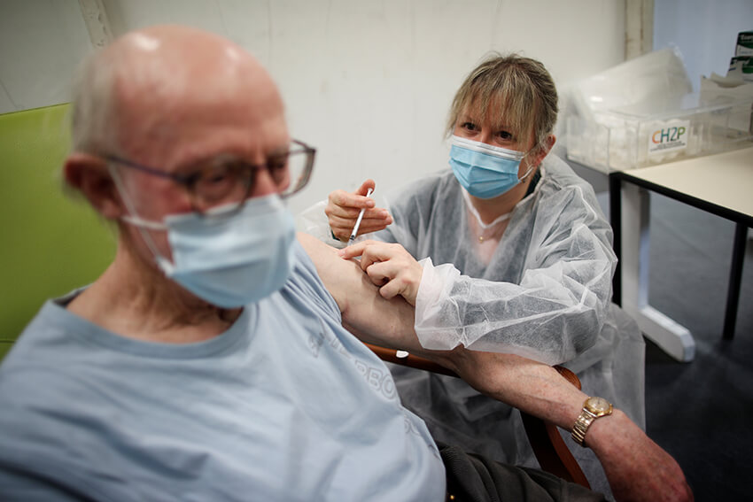 Un anciano, mayor de 75 años, recibe una dosis de la vacuna Pfizer-BioNTech COVID-19 en un centro de vacunación en Lamballe-Armor, Francia, el 22 de enero de 2021.