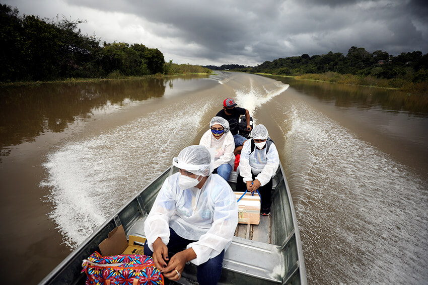 Profesionales de la salud viajan en un bote a orillas del río Solimoes para administrar la vacuna AstraZeneca a los residentes en Manacapuru, estado de Amazonas, Brasil, febrero de 2021. 