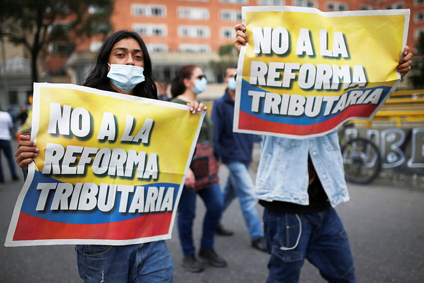 Manifestantes sostienen pancartas con la leyenda "No a la reforma tributaria" del gobierno del presidente Iván Duque en Bogotá, Colombia 28 de abril de 2021.