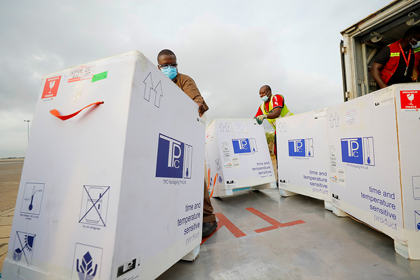 Una serie de trabajadores cargan un camión con 350.000 dosis de vacunas contra la COVID-19 en el aeropuerto internacional de Kotoka en Accra, Ghana, el 7 de mayo de 2021. 