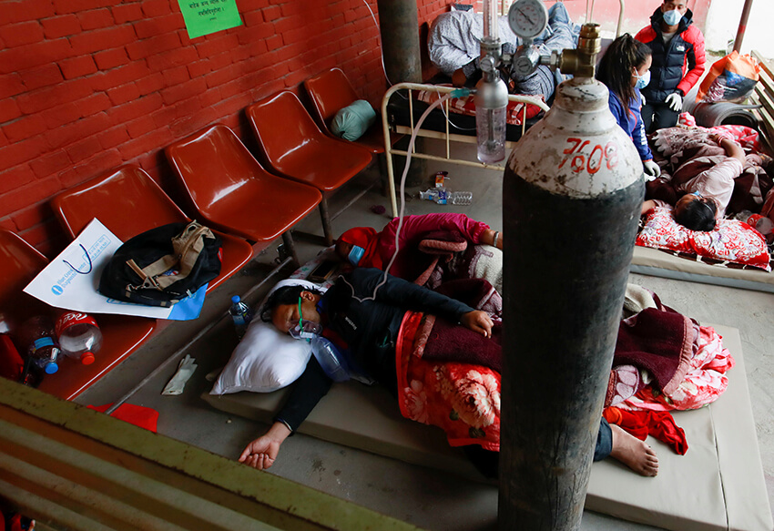 Los pacientes reciben oxígeno mientras duermen en el suelo del pasillo debido a la falta de camas libres en el hospital, Nepal, 10 de mayo de 2021.