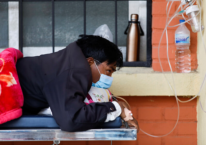 Un paciente recibe oxígeno mientras espera en el pasillo debido a la falta de camas libres en un hospital de Katmandú, en Nepal, 10 de mayo de 2021. 