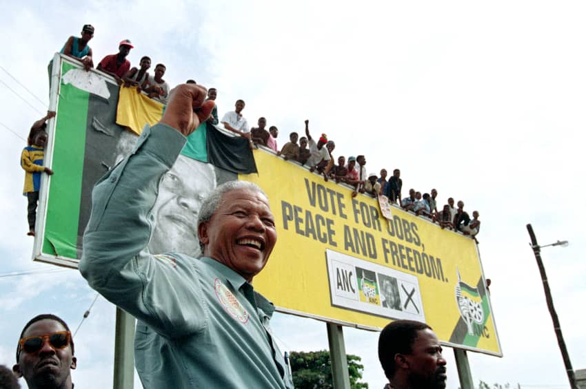 Nelson Mandela saluda a unos jóvenes simpatizantes desde lo alto de una valla publicitaria en un municipio de las afueras de Durban antes de un mitin electoral