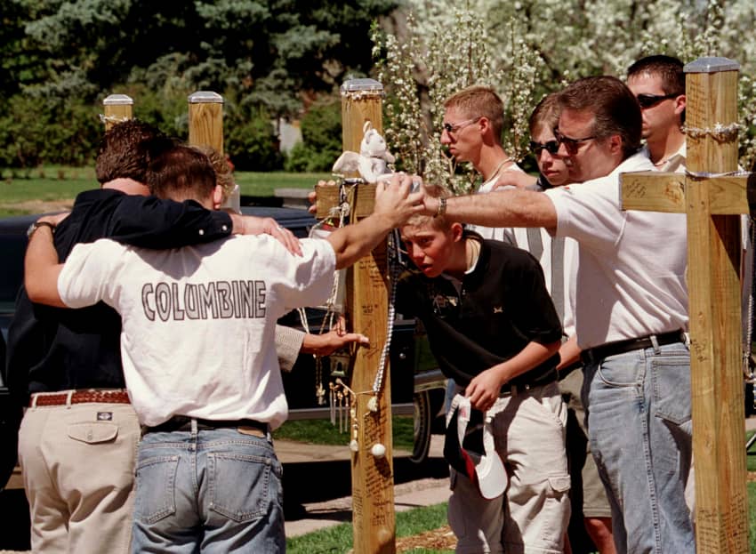 La familia de Corey Tyler DePooter, estudiante del instituto Columbine asesinado, abraza y toca su cruz tras un servicio conmemorativo durante los actos de conmemoración en el primer aniversario del tiroteo. Esta matanza en una escuela de secundaria de Estados Unidos tuvo lugar en 1999e 