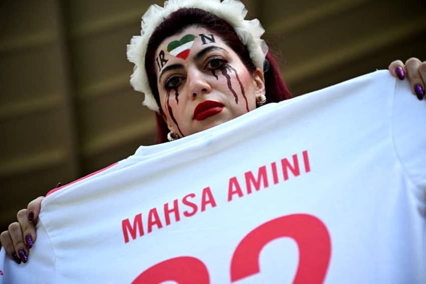 Una aficionada iraní sostiene una camiseta en memoria de Mahsa Amini. Amnistía Internacional denuncia en su informe anual la grave situación de discriminación que padecen millones de mujeres y niñas en países como Irán