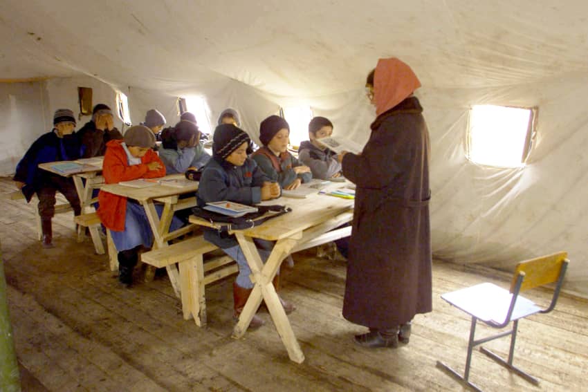 Estudiantes chechenos asisten a clase en una tienda el el campo de personas refugiadas de Karabulak, en Ingushetia