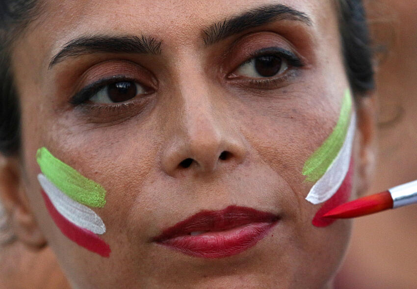 Una mujer pinta su cara con los colores de la bandera iraní durante una manifestación contra la muerte de Mahsa Amini y en solidaridad con los manifestantes antigubernamentales en Irán, en Limassol, Chipre 1 de octubre de 2022