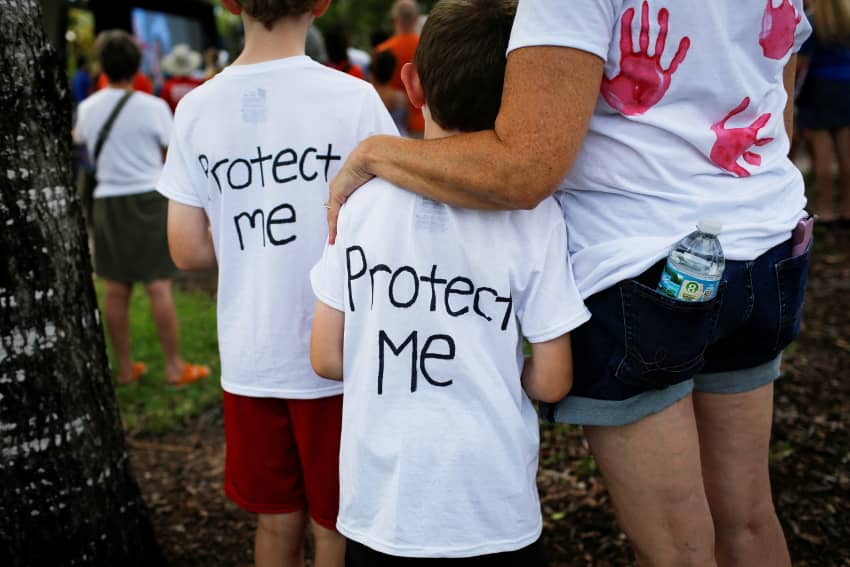 Una mujer abraza a un niño mientras participan en la manifestación "Marcha por nuestras vidas" a favor del control de armas en Parkland, Florida. Cómo detener la violencia armada en Estados Unidos