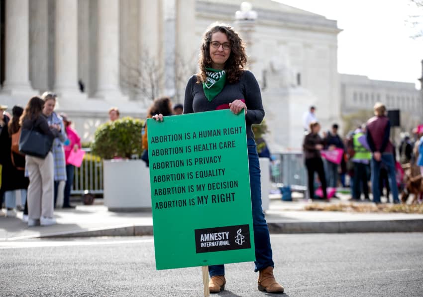 LA Directora Nacional de Programas de Amnistía Internacional Estados Unidos sostiene un cartel en defensa del aborto legal y seguro